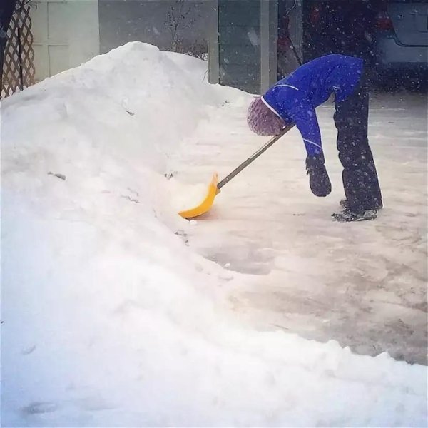 Женщина чистит снег