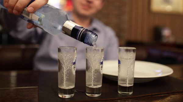 наливает водку